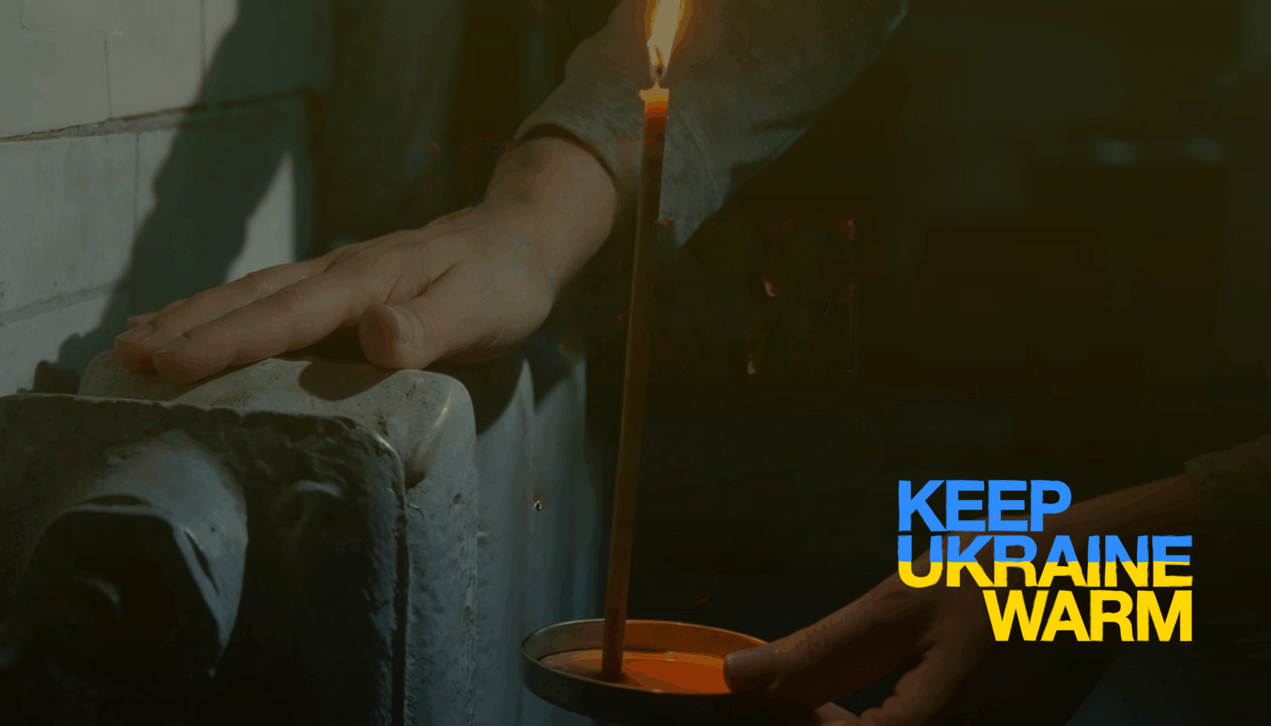 Hand på ett element i ett mörkt rum, med texten ”Keep Ukraine warm”.