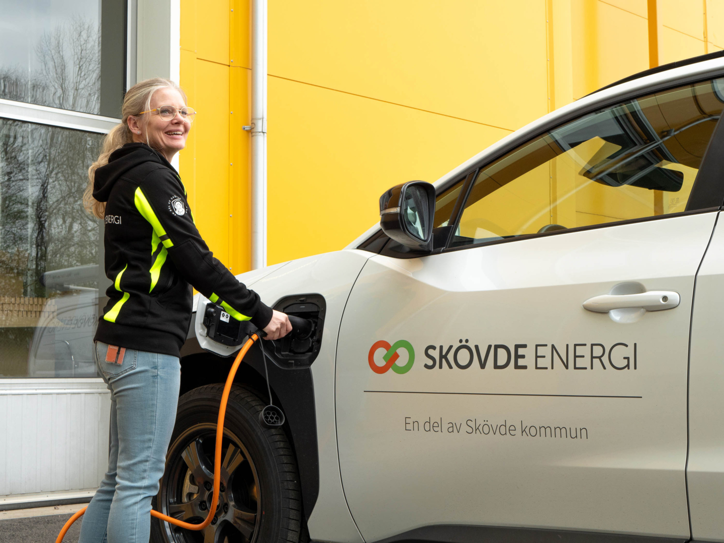 Kvinna laddar en elbil vid Skövde Energi